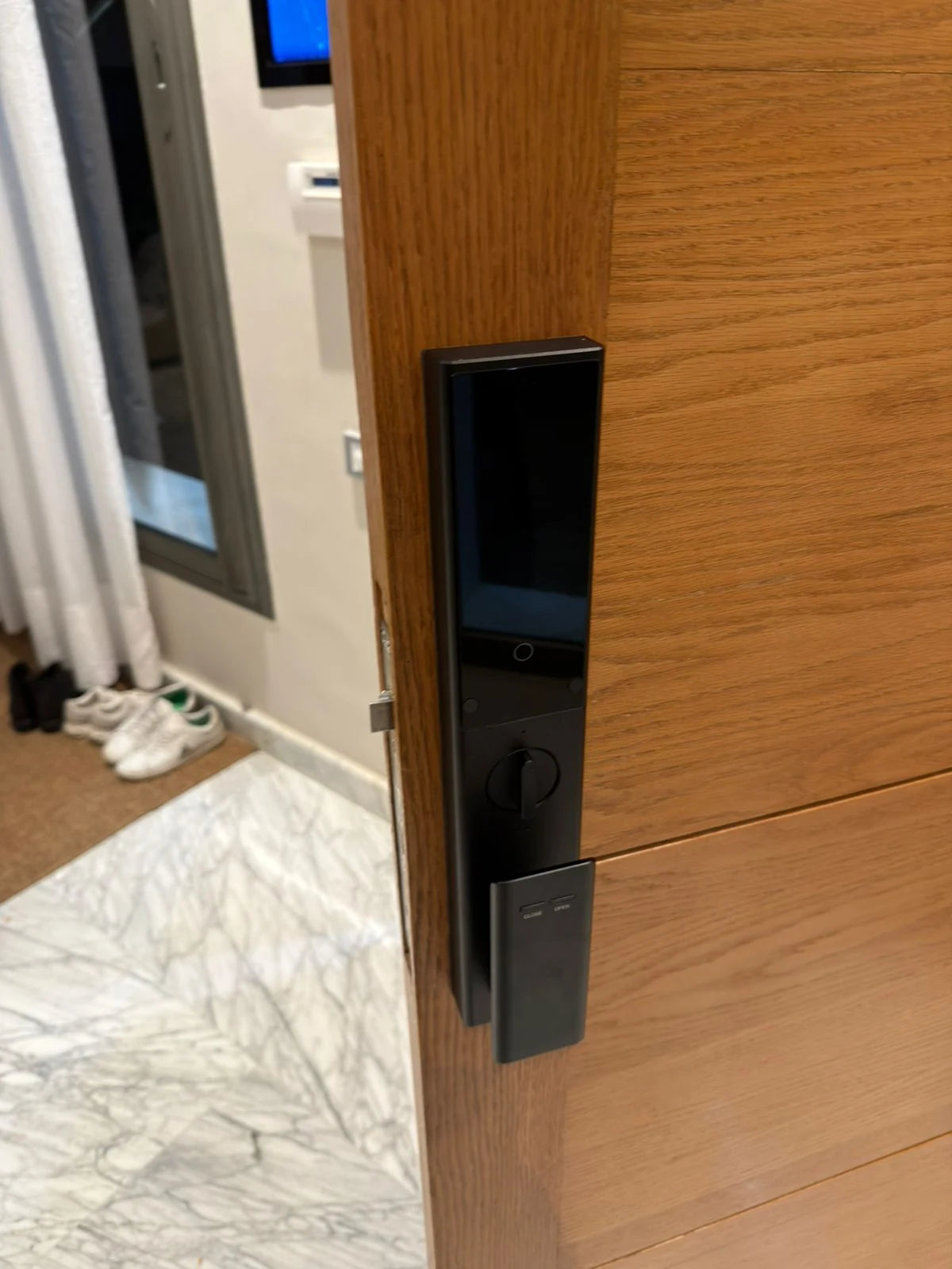 Serrure intelligente Aurex Pro photographiée sur une porte entrouverte au Maroc, réalisation Binaa.