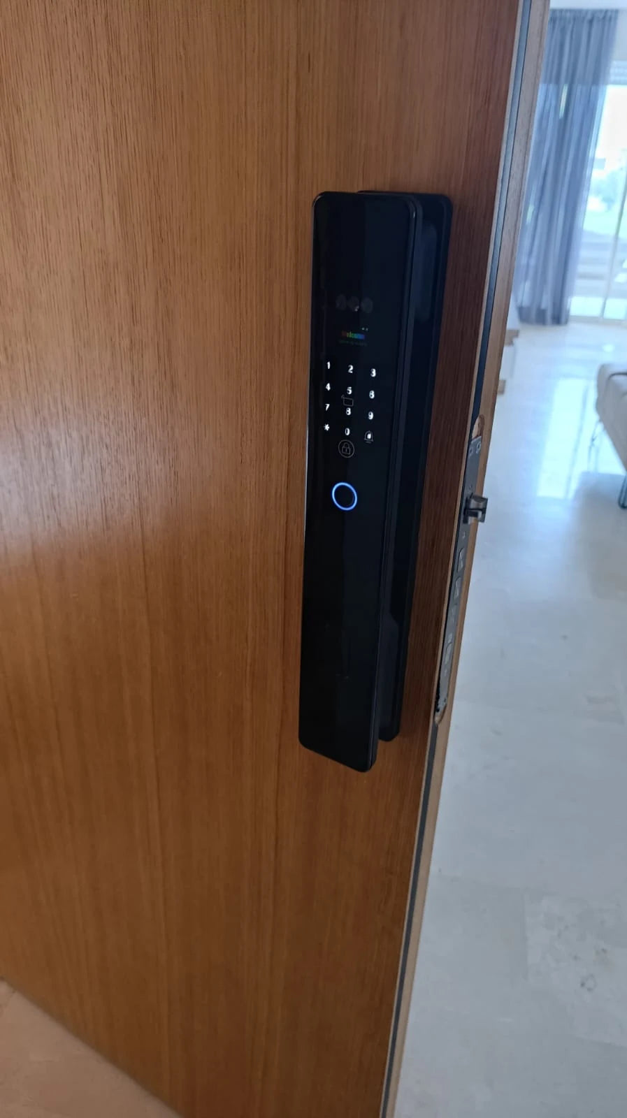 Serrure intelligente XR Max photographiée sur une porte entrouverte au Maroc, réalisation Binaa.